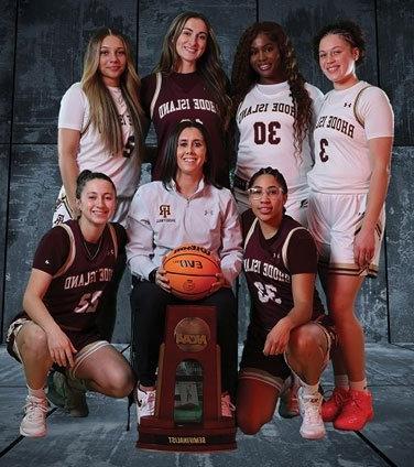 Women's basketball team members with coach Jenna Cosgrove and trophy